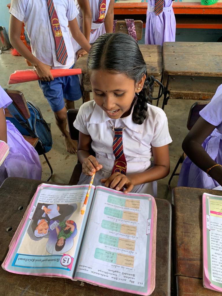 An underprivileged child holding a notebook with hope in their eyes, amidst flood-affected surroundings. Together, we can ensure every child continues their education despite challenges. Support their journey today